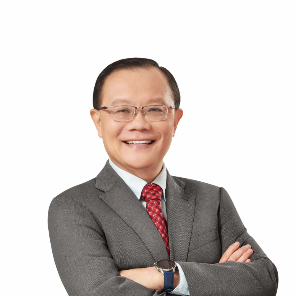 Man in gray suit, red patterned tie, and glasses, arms crossed.